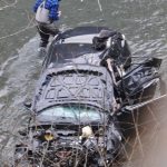 A fisherman examines the wrecked vehicle in the cold waters of the Hoh River. Photos by Lonnie Archibald
