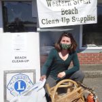 Dakota Truitt (Forks) with a bag of debris, broken chair, and floats she picked up at Shipwreck Point.