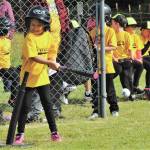 Ahna Hurn connects for a base hit as she swings a pink-tipped bat that matches her pink shoes.