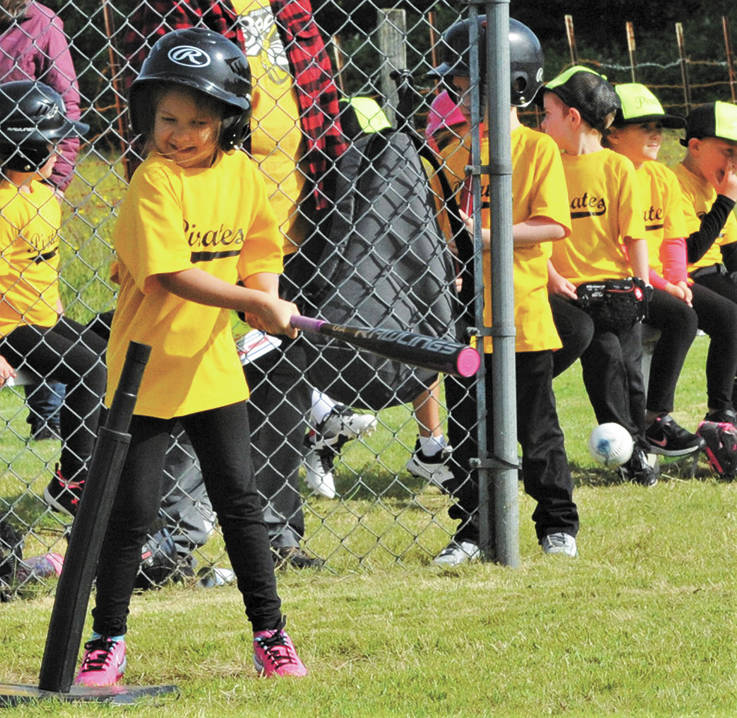 Ahna Hurn connects for a base hit as she swings a pink-tipped bat that matches her pink shoes.