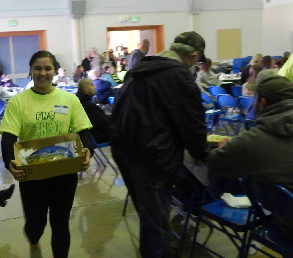 Senior class members were kept busy taking items through the crowd for a closer look …Aspen Rondeau displays a handblown glass river rock …valued at $500.