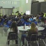 Senior class members stand at the ready to take a bid or answer a question as the large crowd watches the bidding action.