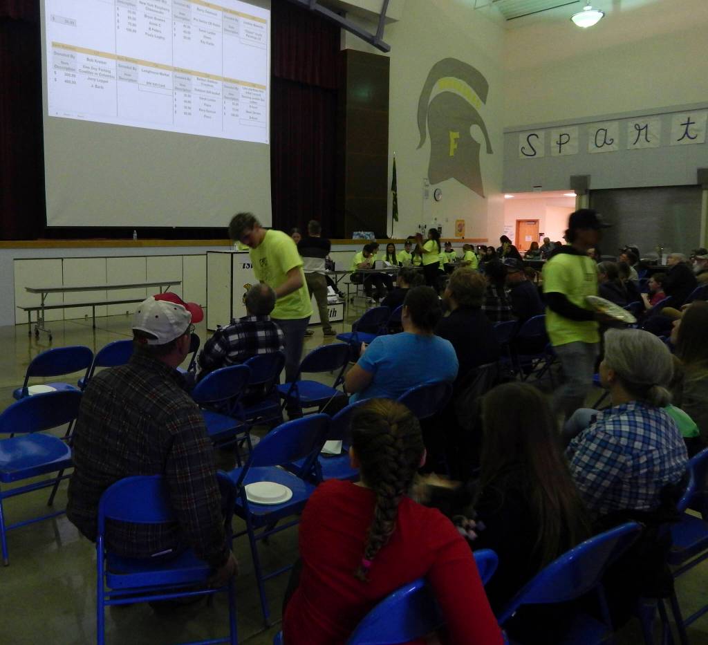 Forks Elementary Principal Matthew Holshouser served as one of the auctioneers for a time on Saturday afternoon …up for bid on the big screen …a fishing trip, cheesecake, a gift basket and a Hoh Tribe paddle.