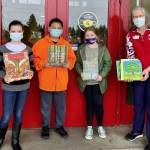 Students accepting eight donated books from the American Elm Heritage Project to the Forks Middle School are (from left) Brooklynn Rondeau, Riley Jackson, Kylee Roberts. Virginia Wagner, Michael Trebert Chapter representative (right) presented the books to the students. Submitted Photos