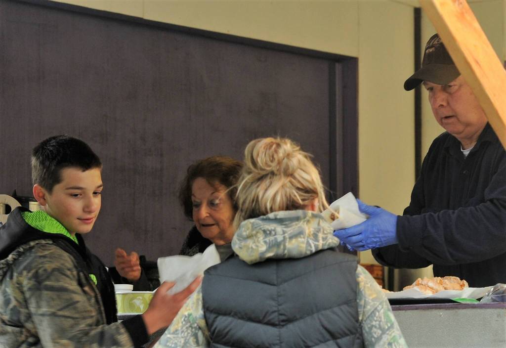 Patsy and Chuck Jennings are seen handing out hotdogs, donuts, hot chocolate, etc from the Forks Elks Club booth during the Kids Fishing Day.