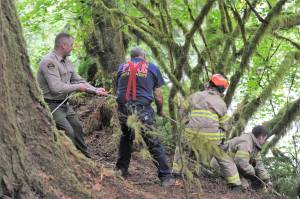 Clallam County Sheriff personnel and Fire department personnel pull to lift a dog from the bank of the Sol Duc River. Photo by Lonnie Archibald