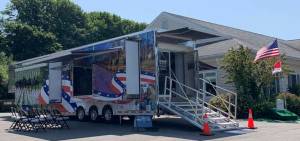 This customized 60-foot-long trailer contains displays and a theater. It is staffed with knowledgeable volunteers dedicated to honoring fallen American service members. Photo Wreaths Across America