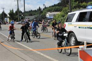 The Fun Days parade begins with bicycle riders escorted by the Clallam County Sheriffs Department. Photo by Lonnie Archibald