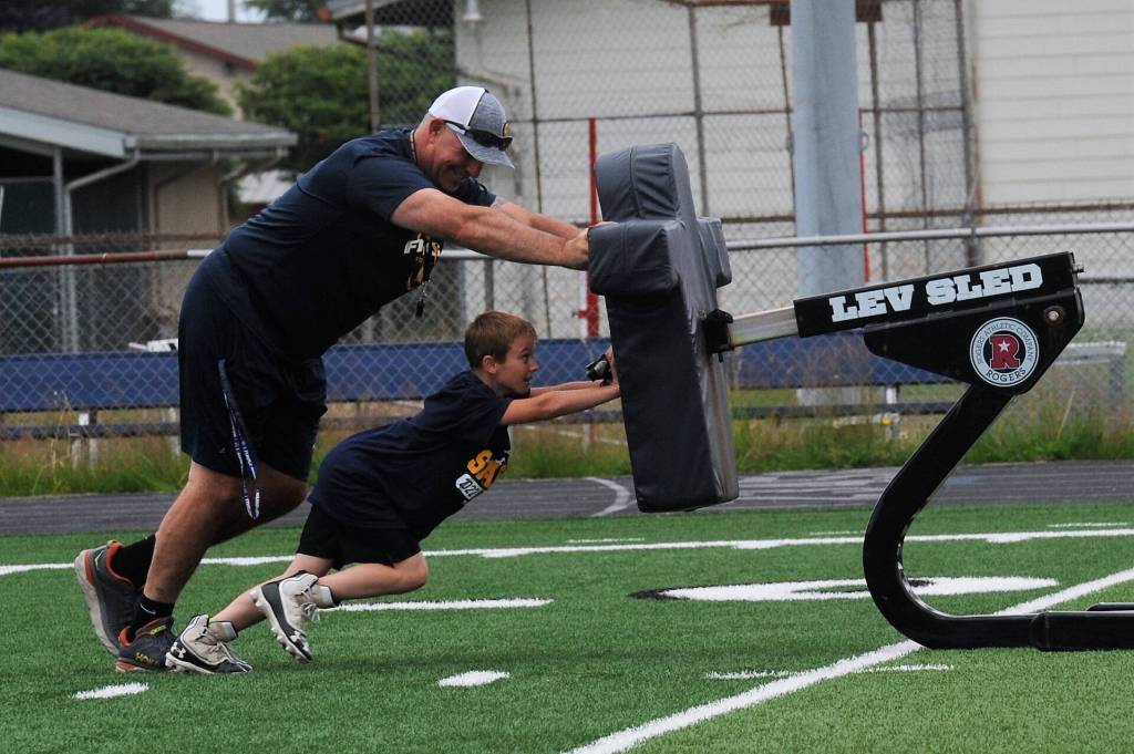 Tweleve-year-old Jeremiah McPherson teamed up with coach Trevor Highfield moving the sled downfield here at Spartan Stadium.