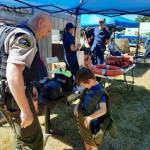 Sean Hoban with the Clallam County Sheriffs Office offered a vest demonstration to those that wanted to try it on. Hoban was also strategically placed next to the Bank and the Jail.
 USCG Station Quillayute River members, seen in the background, also participated, with a lifevest demonstration.