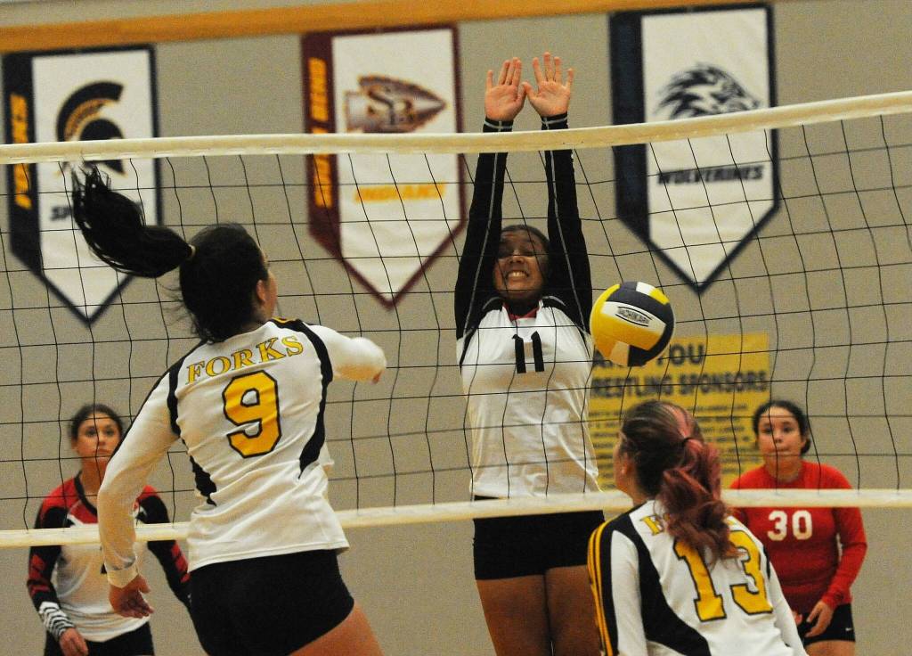 In this JV contest, Q Greene attempts to block a hit by Spartan Morgan Rule (9). Also in on the action is Haven Hoffman (13).