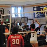 In JV action Spartan Reagan Dunn (7) hits against the Red Devils while official Randy Rooney looks on.