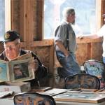 Barry Swanson reads of old-time log trucking while Joe Gaydeski and Pat Ruble share stories of the past.