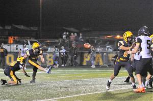 Landen Olson (10) holds while kicker Walker Wheeler (23) kicks another ball through the uprights. Blocking is Camryn Kennedy (8). Photo by Lonnie Archibald