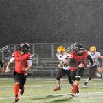 Red Devil QB Julian Carrick (5) finds running room behind the blocking of teammates Jodell Wimberly (1) and Charles Halttunen (12) during a rainy evening in Forks where Neah Bay defeated Winlock 56 to 6 earning their way into the state playoffs in 1B 8 man football. The Red Devils will face the winner of the Pomeroy/ Wellpinit game on Nov 18 or 19 with the time and place yet to be determined. Photo by Lonnie Archibald
