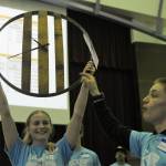 Kadie Wood holds up a whiskey barrel clock while Klayton Helvey comments on the item up for bid. Photo by Lonnie Archibald