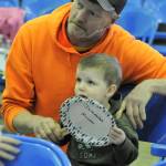 With the help of Andy Krume, two-year-old Jeremiah Krume makes his bid at the scholarship auction Saturday. Photo by Lonnie Archibald