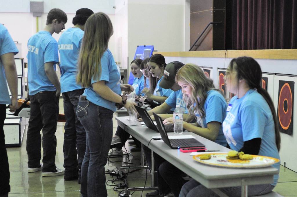 Forks seniors enter bids on an overhead projector during Saturdays Scholarship Auction at Forks High School. Photo by Lonnie Archibald