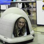 Forks senior Zoie Davis demonstrates a dog house up for bid Sunday during the Quillayute Valley Scholarship Auction. Photo by Lonnie Archibald
