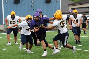 Spartans Kenneth Daman (92), Noah Foster (2), Carter Tossie (35), and John Parker Jr (69) converge on this Sequim running back. Photo by Lonnie Archibald