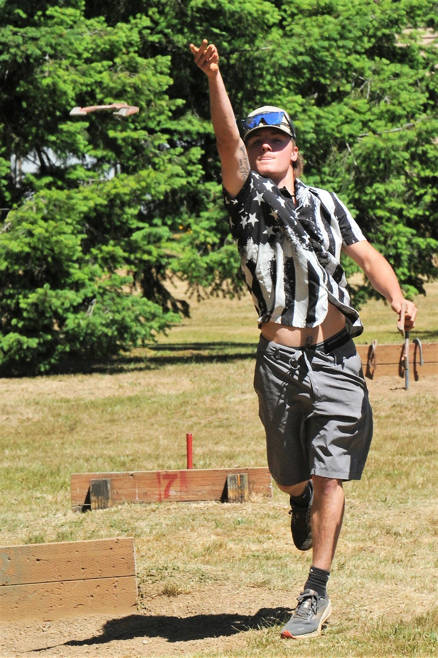 Dalton Kilmer throws a shoe in hopes of another ringer Saturday at Tillicm Park during the annual Horseshoe Tournament. The team of Floyd McCoy and Dalton Kilmer took first place. Photo by Lonnie Archibald