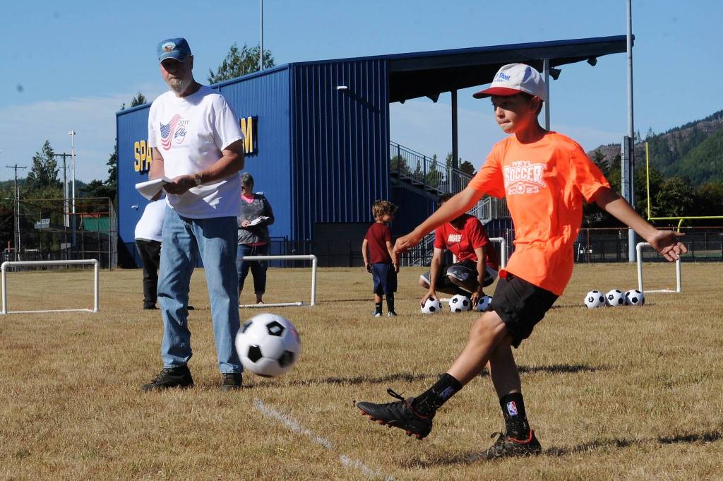 Declan Weekes, age 10, competes while Elks member Rufus Kain keeps score.