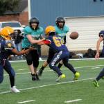 Forks 8th-grade quarterback Thomas Penn pitches to running back Ryder Fletcher (16) while Andres Silva (62) blocks during a game played at Spartan Stadium where Sequim defeated the Spartans 25 to 12. Photo by Lonnie Archibald