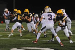 Spartan Nate Dahlgren (40) finds a hole behind the blocking of Walker Wheeler (63) and DeAnthony Davila (20) en route to a touchdown against Pe Ell/Willapa Valley Friday night in Forks where the Spartans defeated the Titans 21 to 18. Photo by Lonnie Archibald