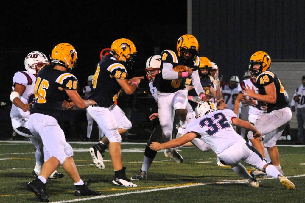 Spartan QB and defensive back Emmanuel Hernandez hurdles a Pe Ell player after intercepting a Titans pass as Forks defeated Pe Ell/Willapa Valley 21 to 18 in a thriller. Also in action for Forks are Brody Lausche (46), Sawyer Graham (59) and Nate Dahlgren (40). Photo by Lonnie Archibald