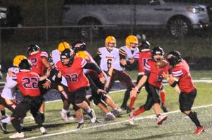 Red Devil quarterback Josh Greene pitches to running back JoJo Wimberly who ran in another touchdown against the Cardinals during a rainy and windy game last Friday. Photo by Lonnie Archibald
