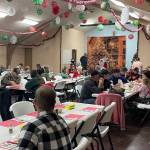 The Church Fellowship Hall was festively decorated. A steady stream of people kept volunteers and Santa hopping. Photo Christi Baron