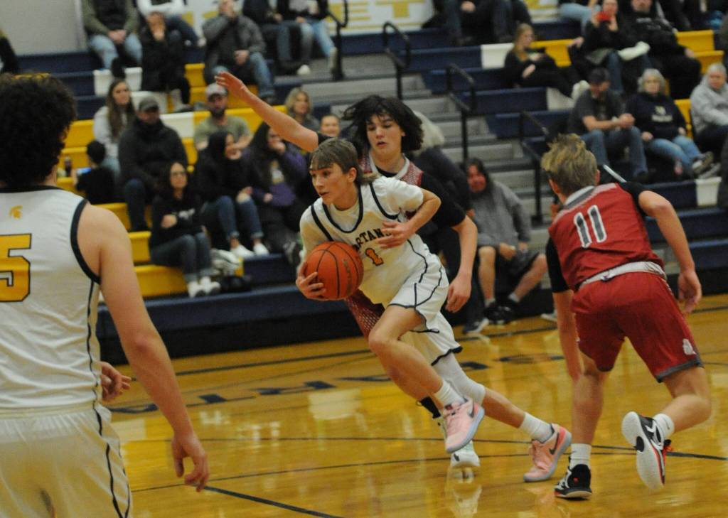 Spartan Kyle Lohrengel drives against the Grizzlies while Landin Davis looks on. Photo by Lonnie Archibald