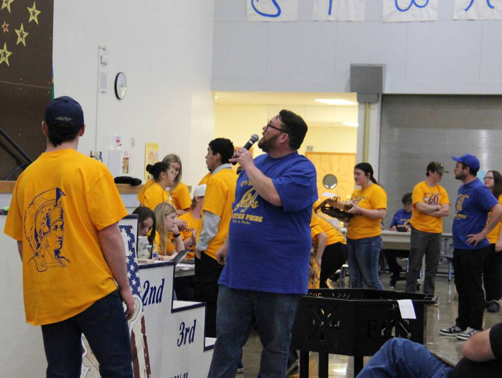Elliott takes a turn at auctioneering as the metal fire pit seen behind him is being bid on. The fire pit and other amazing metal items were created by FHS students in their shop class.