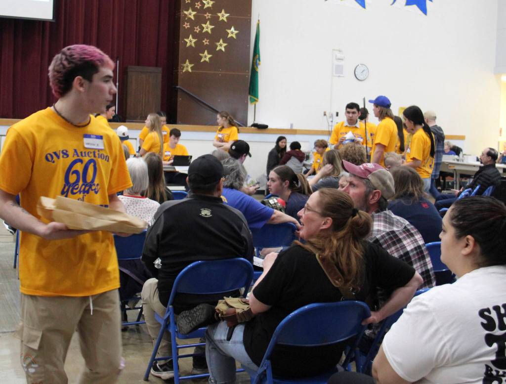 Forks senior Walker takes around an item so that bidders can get a better look.