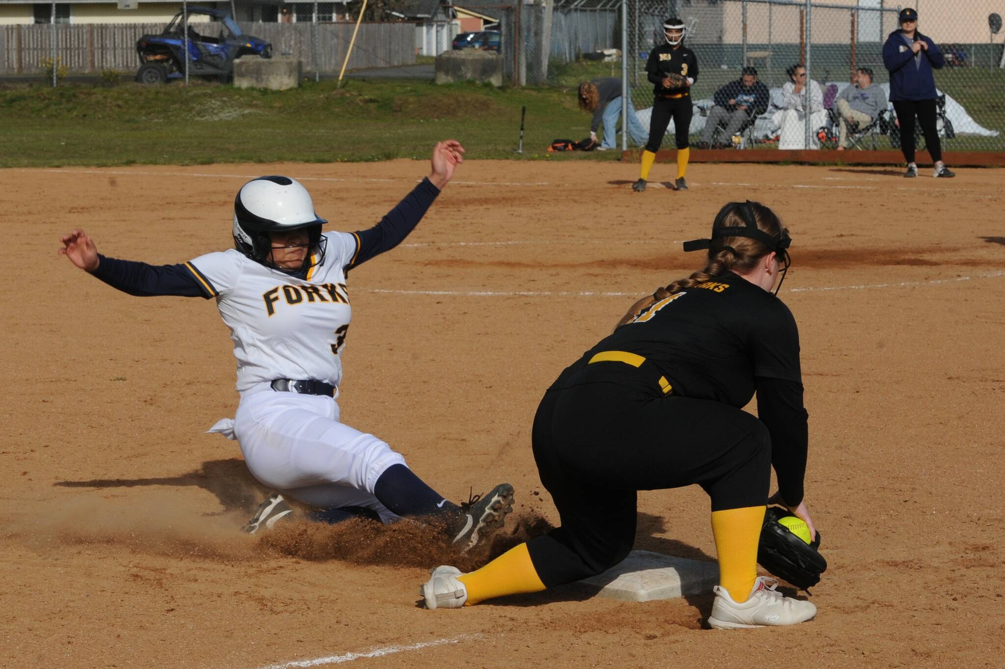Spartan Donny Williams turns up the soil as she slides safely into third ahead of the throw in this contest in which the Forks Jvs defeated the North Beach varsity 20 to 5 at Tillicum Park. Photo by Lonnie Archibald