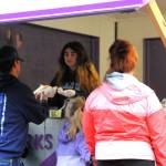 Volunteer Isabella Hayworth passes out hot dogs to one of the many Kids Fishing Day attendees who stopped by the Elks Food Booth for their hot chocolate, hot dogs, and more on Sunday morning.