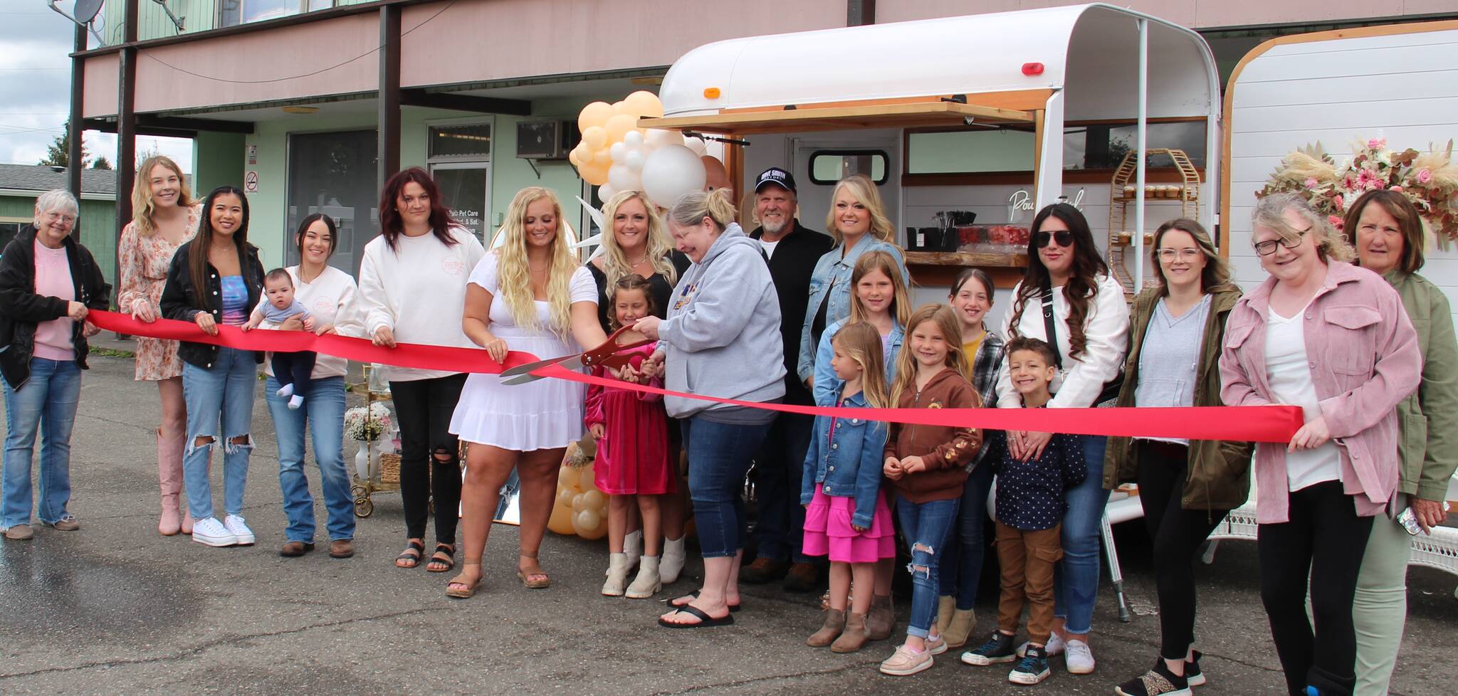 Jaime Henrys Occasions and Creation by Jaime held a Grand Opening for her newest business activity called Pour Girl Mobile Bar on Saturday outside Root 101 in downtown Forks. The event was celebrated with a Forks Chamber of Commerce ribbon cutting. Jaimes friends, family, and supporters came to help mark the occasion with mimosas and snacks. Jaime is seen center of the photo with Forks Chamber Executive Director Lissy Andros as they cut the ribbon. The mobile bar is available for rent for your next wedding, party, etc. For more information call 360-640-8928. Photo Christi Baron