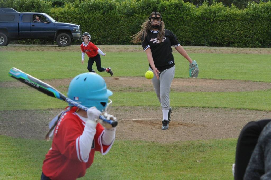 Scrap Yard Dawgs pitcher Chazlynn Fryberg pitches to the Pride while a Pride runner leaves second base.