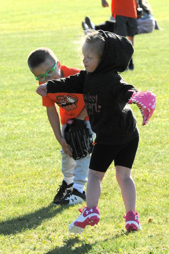 A Tiger teammate looks on while Harper Fletcher goes through calisthenics while awaiting the next Rockies batter.