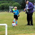 With Elks member Chuck Jennings keeping score, six-year-old Huxley Weekes kicks towards the goal.