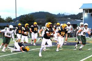 Spartan Emmanuel Hernandez-Stansbury on his long TD run against the Roughriders in the first quarter of play Friday night at Spartan Stadium. Also in the action are Spartans Landen Olson (10), Kaden Ward (23), Cash Barajas (11), Kenny Daman (75), and Jeremy Hutto (72). Forks defeated Port Angeles 13 to 7. Photo by Lonnie Archibald
