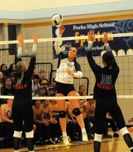 Spartan Avery Dilley (11 ) hits against East Jeffersons Emily Lisk (8) and Penina Vailolo (15) on Sept. 26 in the Spartan Gym where Forks, after losing the first set, came back to defeat the Rivals 3 to 1 in this nonleague contest. Photo by Lonnie Archibald