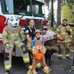 Sparky and the Forks Fire Department volunteers entertain a cute scarecrow.