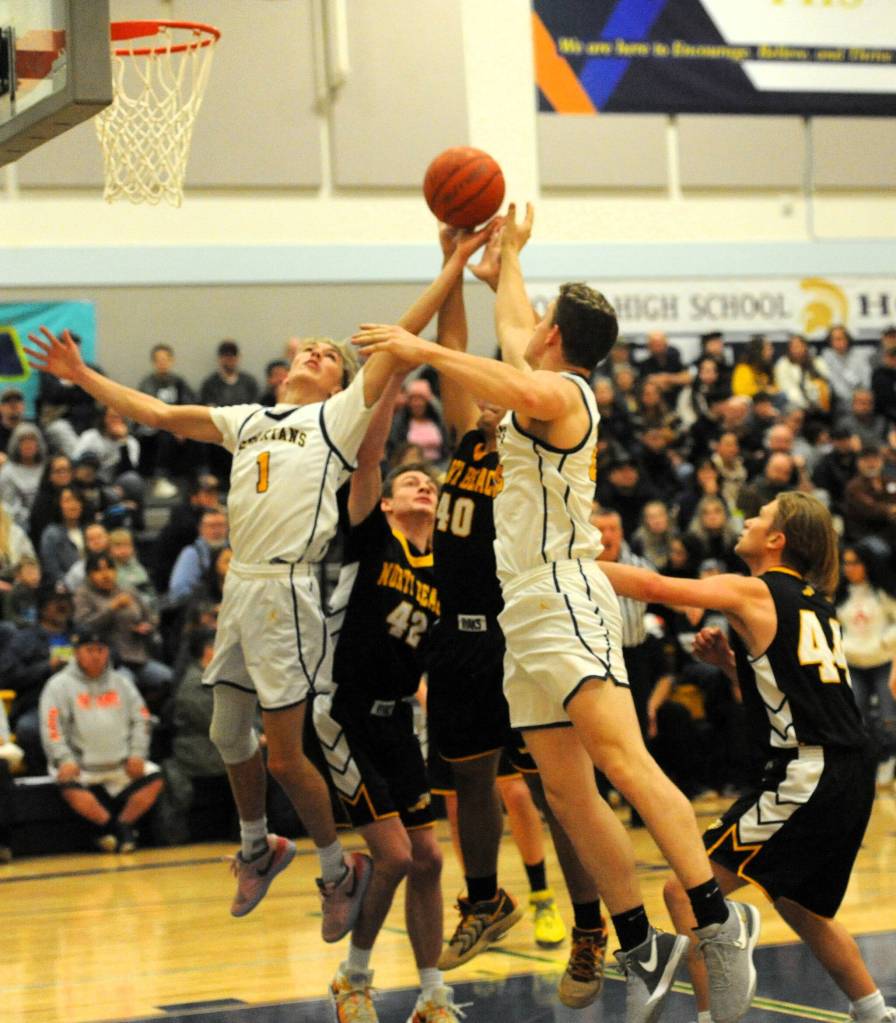 Spartan Seniors Kyle Lohrengel (1) and Brody Lausche (22) rebound before a packed house at Spartan gym on Senior Night.