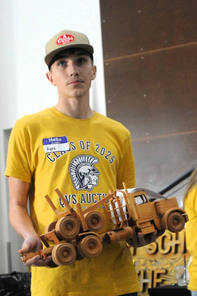 Photo by Lonnie Archibald
Kyle Lohrengel holds a log truck up for auction. The Olympic Corrections Center wood shop once again created many items for the auction.