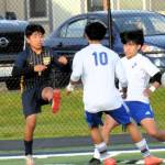 Forks Eduardo Calmo, who later scored the second goal for Forks, kicks between two Eagle defenders.