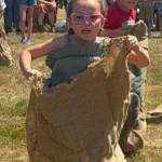 Corey Stensland, age 5, great-granddaughter of Rick and Pam Gale, with the win, in the Gunny Sack Race, Sunday in Tillicum Park. Her cousin, Aubrey Gale, can be seen in the background, cheering her on. 
Photos by Pam Gale