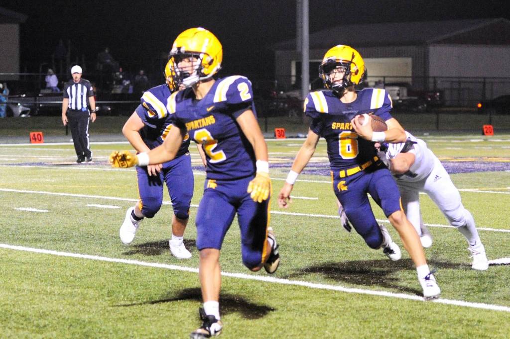 Spartan quarterback Lane Helvey (6), in place of an injured Landen Olson, picks up yardage behind teammate Noah Foster (2).