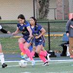 Forks Jade Blair controls the ball against the Ravens. Also, in the action is teammate Kim Camacho.
