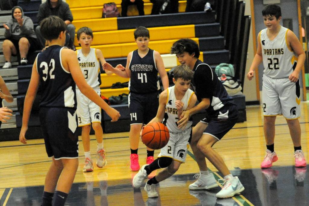 Photo by Lonnie Archibald
Driving the lane is Spartan 7th grader Jaxon Koskela. Also in the action are teammates Declan Weekes (3), and Kaden Woody (22). With only six players suited up for the Forks 7th grade, they still competed with Stevens of Port Angeles, losing 25 to 20. One of the scrapiest teams I have seen, these Forks 7th graders.